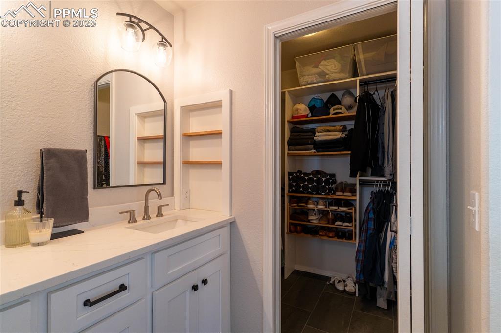 Image 14 of 26: Bathroom featuring vanity, dark tile patterned floors, and a spacious close