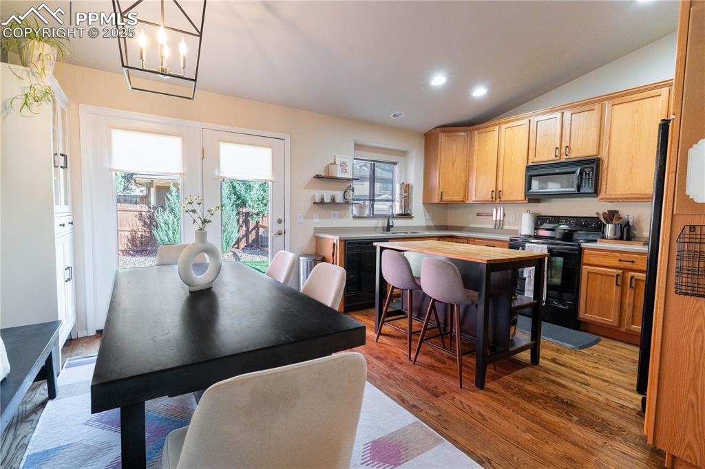 Image 15 of 26: Kitchen featuring recessed lighting, black appliances, dark wood-type floor