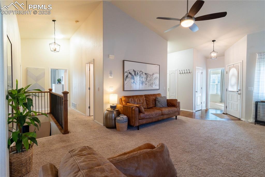 Image 18 of 26: Living area featuring carpet flooring, high vaulted ceiling, and a ceiling