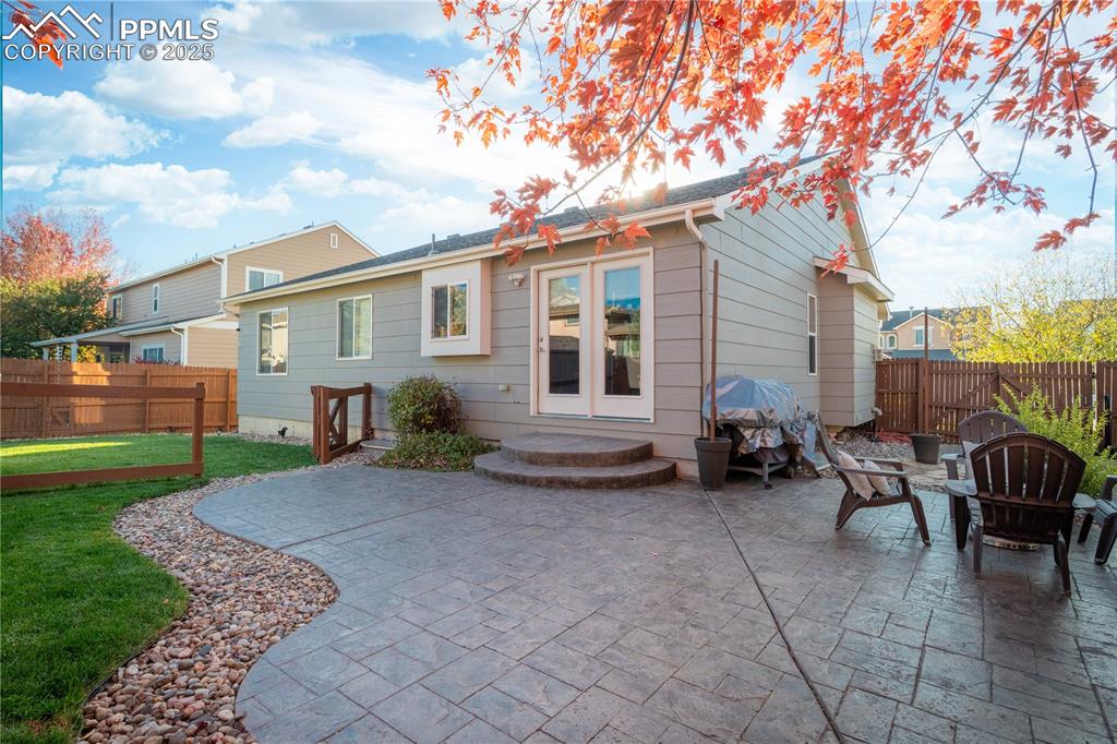 Image 2 of 26: Rear view of house with a patio area and a fenced backyard
