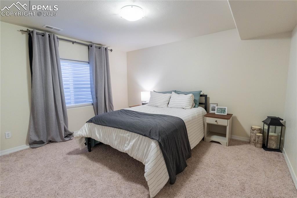 Image 23 of 26: Bedroom with light colored carpet and baseboards
