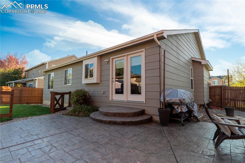 Image 3 of 26: Rear view of house featuring a fenced backyard and a patio