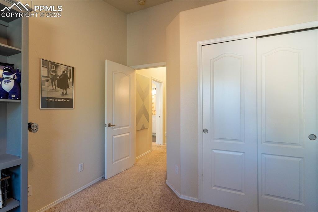 Image 8 of 26: Bedroom featuring light colored carpet and a closet