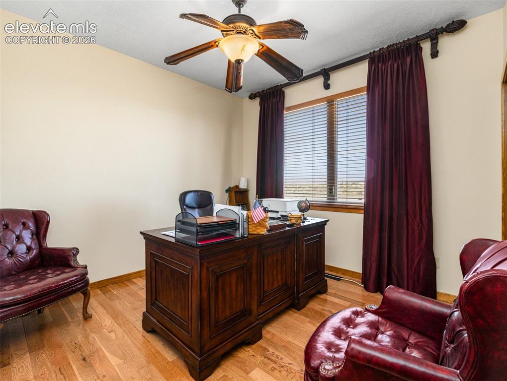 Image 23 of 44: Wood-finish flooring, ceiling fan with integrated lighting, window with bli