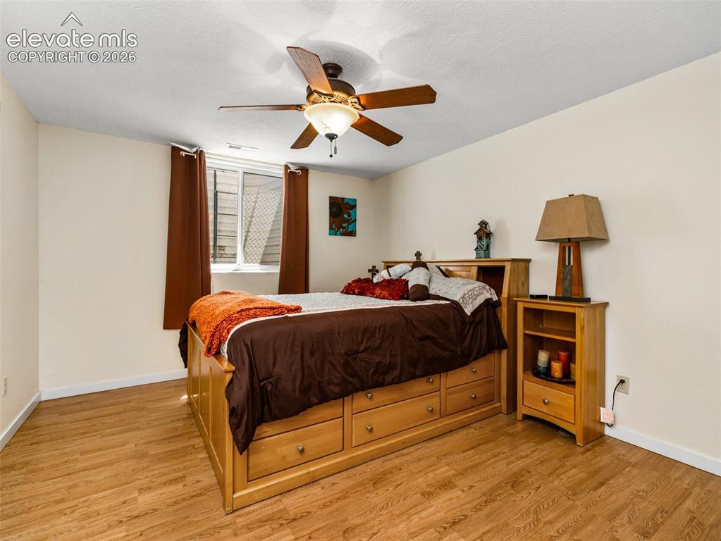 Image 26 of 44: Wood-finish flooring, ceiling fan with integrated lighting, and a white win