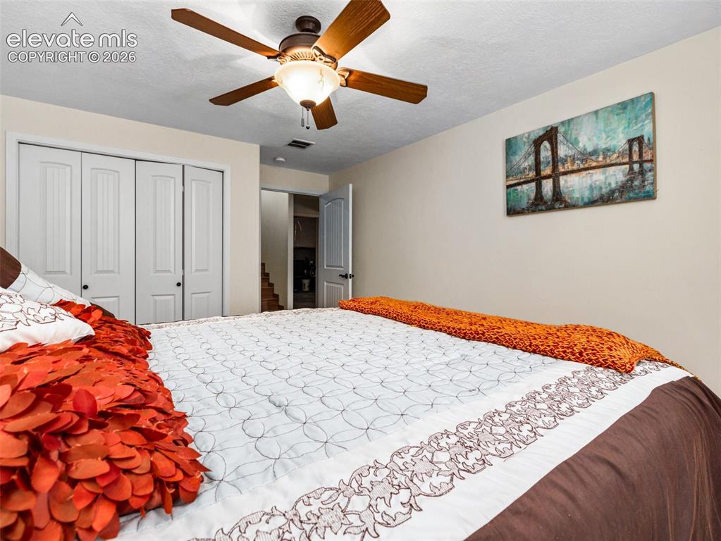 Image 27 of 44: Ceiling fan with integrated lighting, bi-fold closet doors, and light-color
