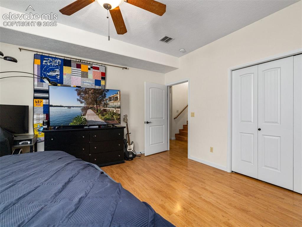Image 29 of 44: Wood-finish flooring, ceiling fan with integrated lighting, and white bi-fo