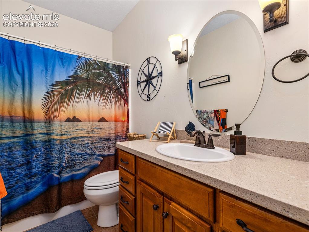 Image 30 of 44: Bathroom with a single vanity featuring a light-colored countertop and a dr