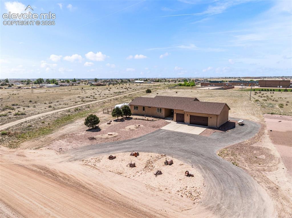 Image 34 of 44: Single-story residence with a multi-car garage, asphalt driveway, and a bro