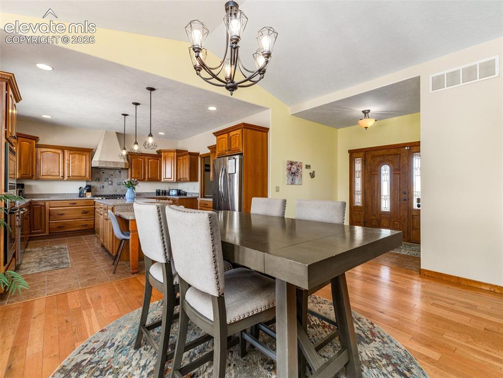 Image 4 of 44: Wood flooring, vaulted ceiling, wood cabinetry, stainless steel appliances,