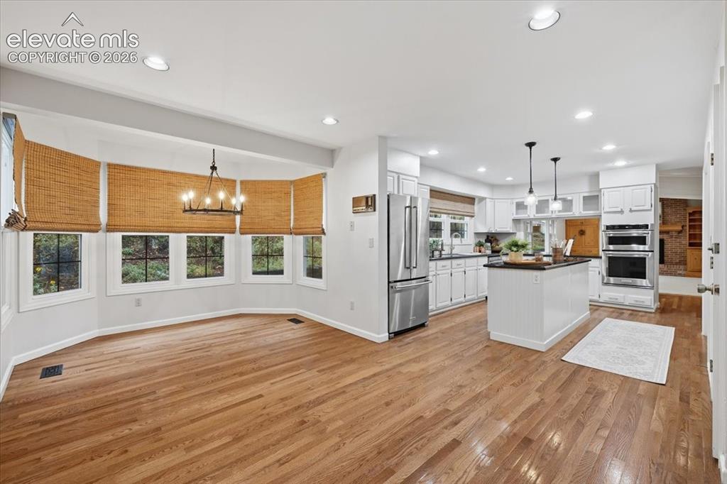 Image 12 of 49: View of dining area into kitchen, hardoows throughout this area