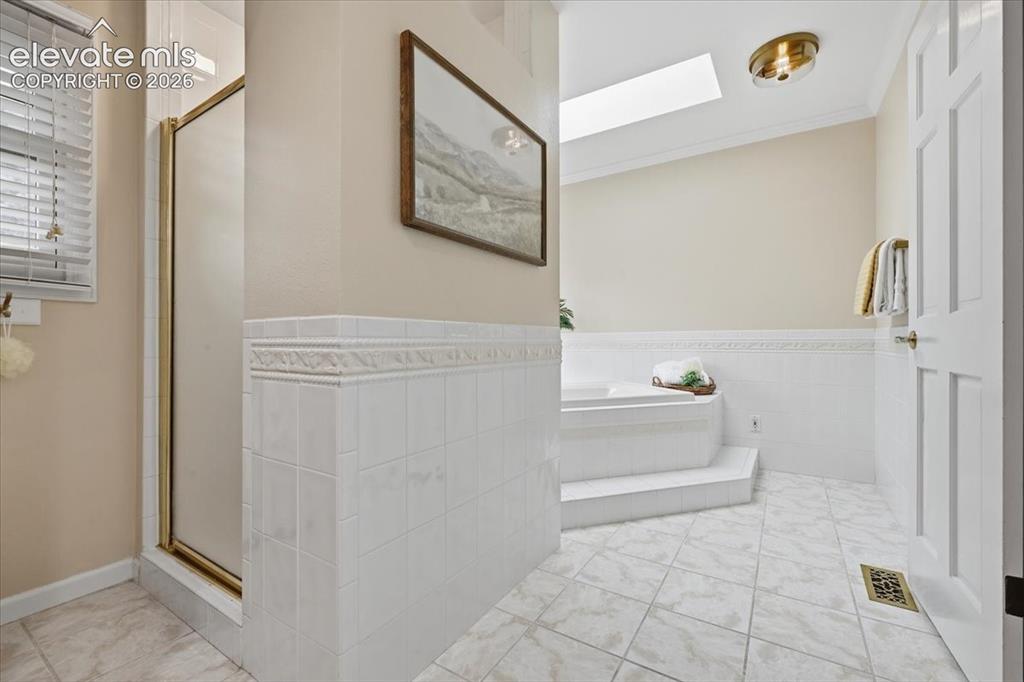 Image 22 of 49: primary bathroom huge soaker tub with window viewing treed hillside