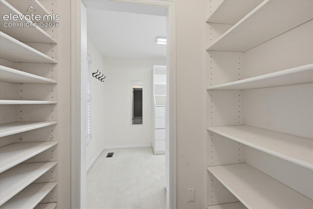 Image 26 of 49: Primary bedroom HUGE walk in closet the size of a small room