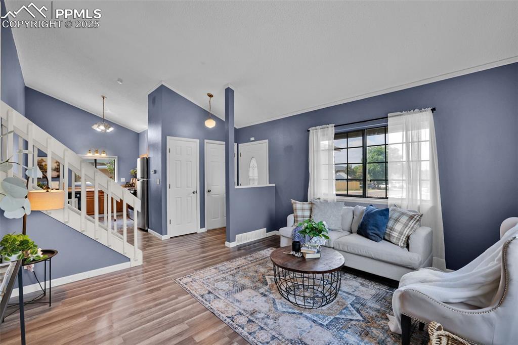 Image 2 of 34: Living room has slanted vaulted ceilings