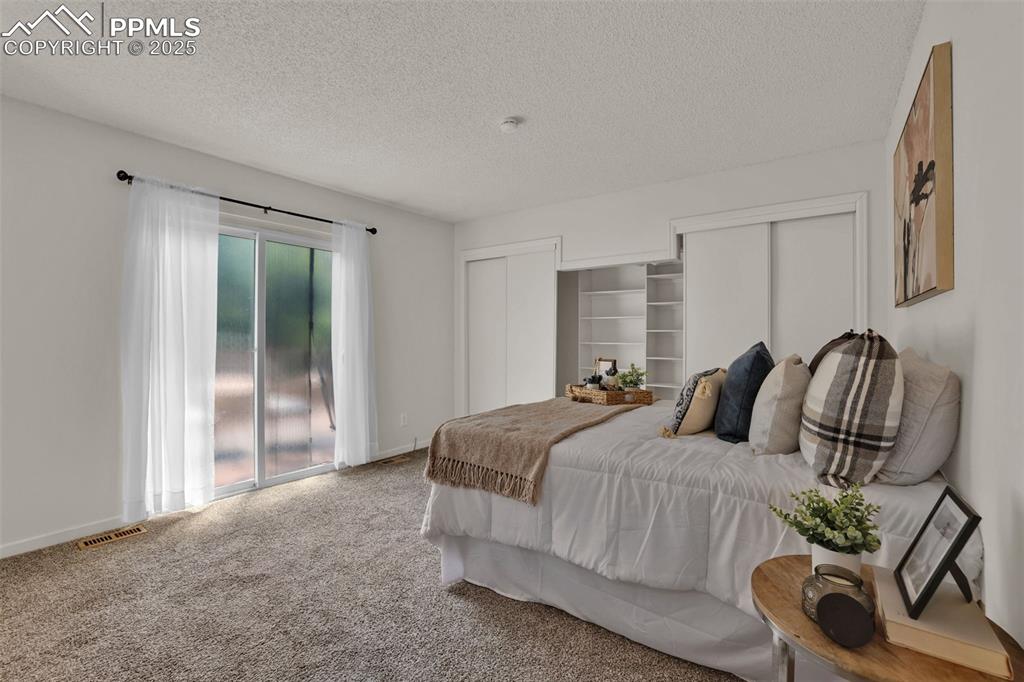 Image 4 of 34: Primary bedroom with walk out to the deck