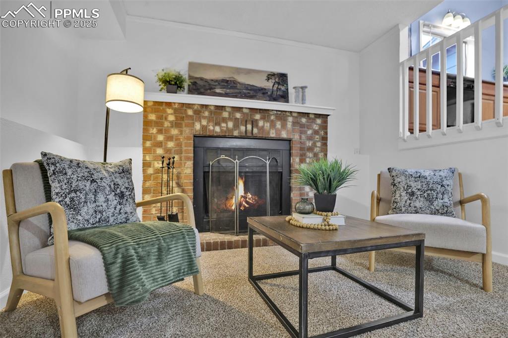 Image 5 of 34: Lower level living room with wood burning fireplace