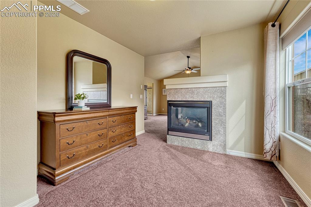 Image 28 of 50: The panoramic fireplace beautifully divides the sleeping quarters from a pr