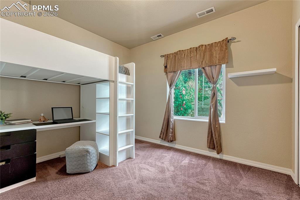 Image 38 of 50: The sprawling finished basement offers a secondary living space centered ar