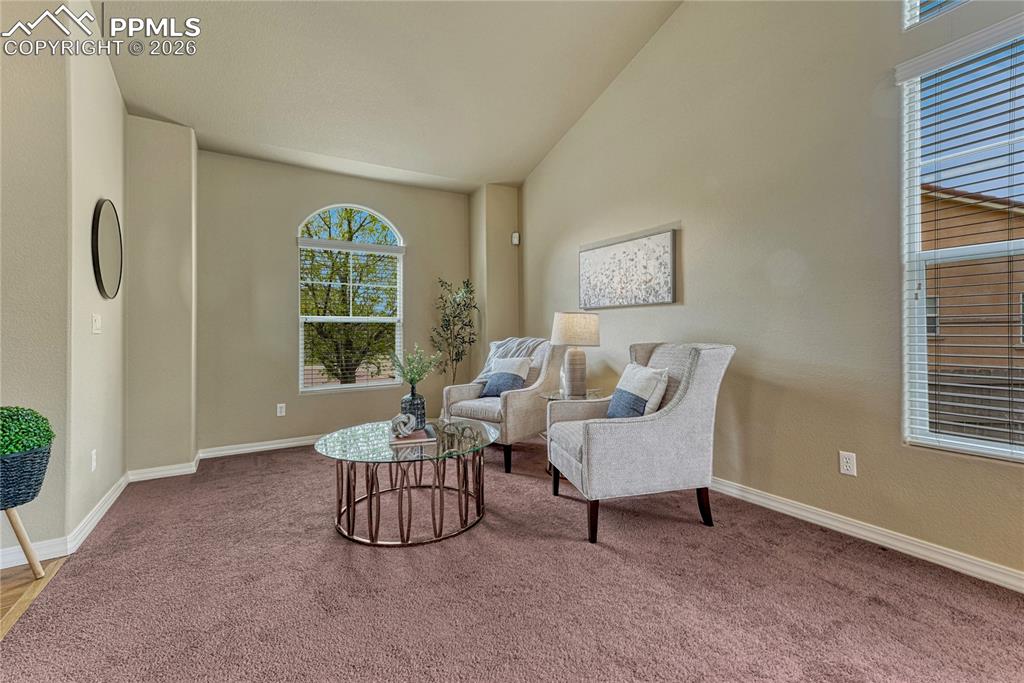 Image 6 of 50: Step inside to an open layout featuring hardwood floors and vaulted ceiling