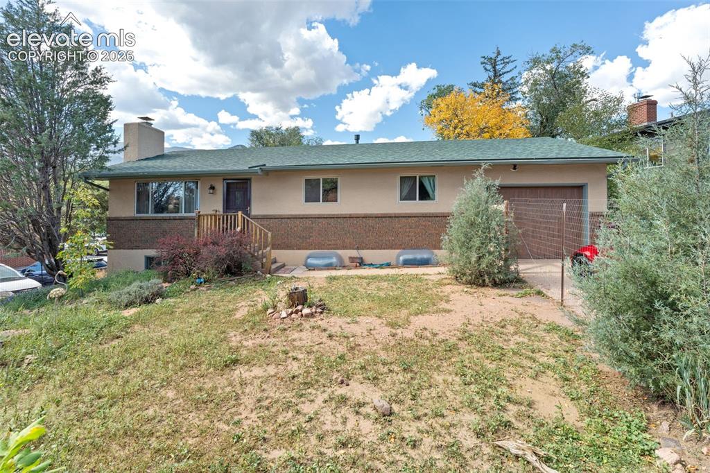 Caption: Split-level residence featuring a brick and stucco exterior, an attached single-car garage, and a co