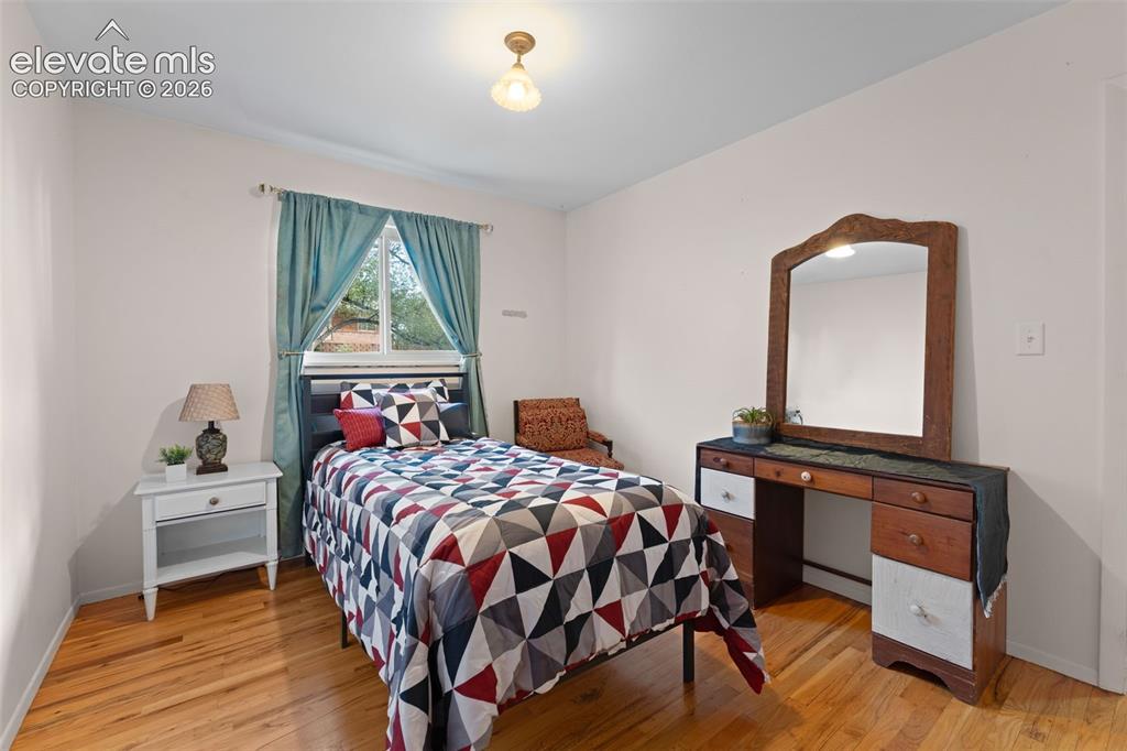 Image 10 of 50: Hardwood flooring, painted white walls, ceiling-mounted light fixture, and