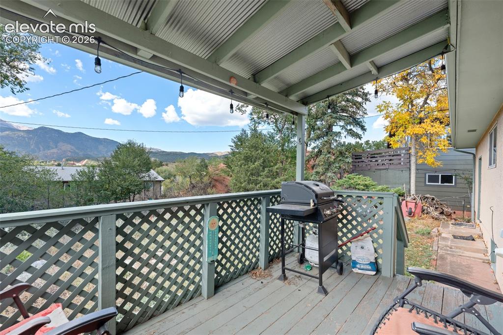 Image 11 of 50: Covered outdoor deck with painted wood flooring and lattice railing