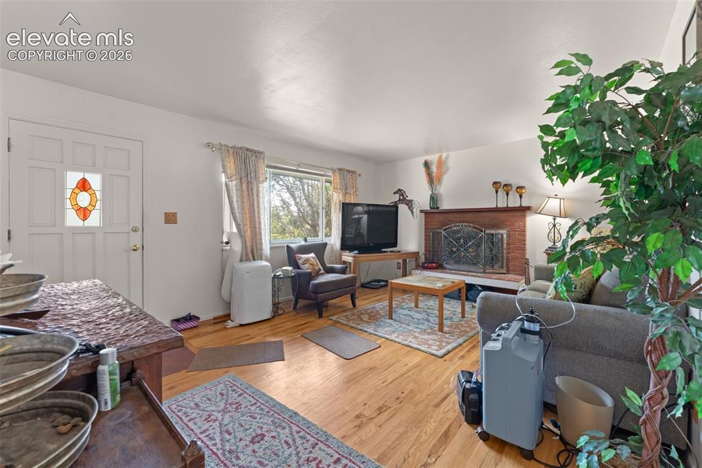 Image 12 of 50: Hardwood-finish flooring, a white paneled entry door with stained glass ins