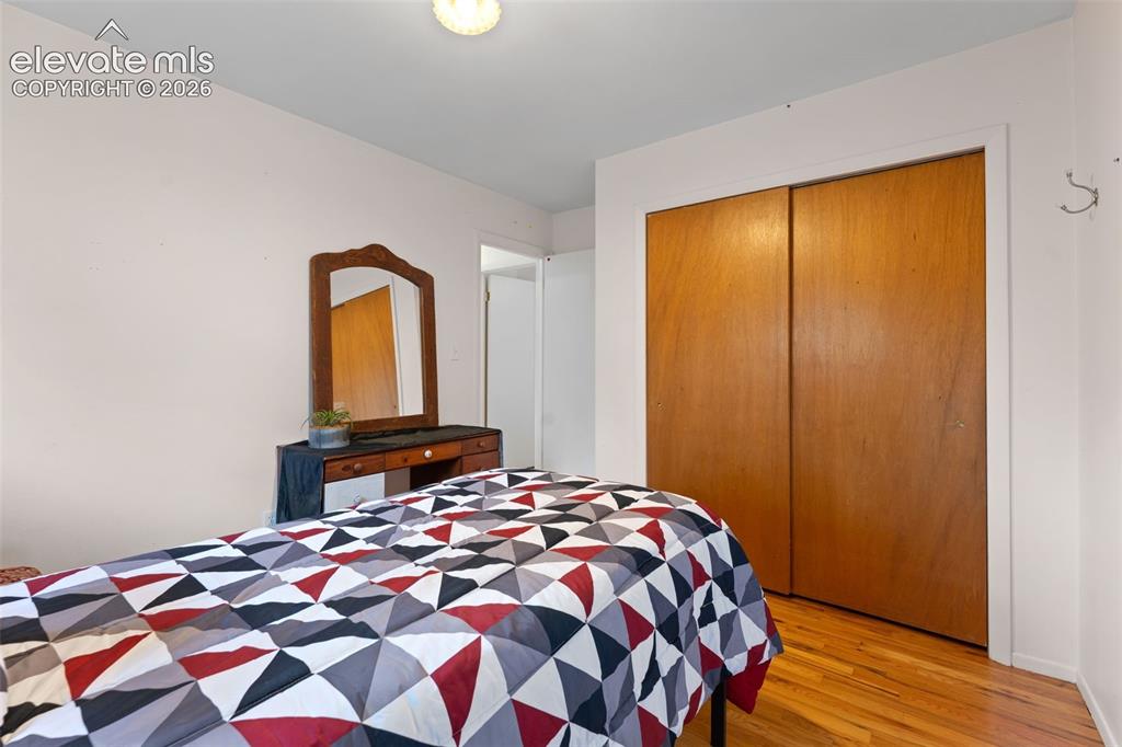 Image 19 of 50: Hardwood flooring and a built-in closet with sliding wood doors