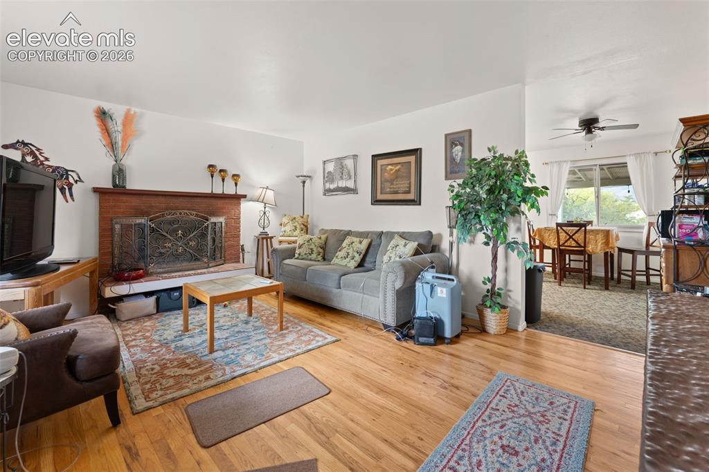 Image 2 of 50: Hardwood flooring, brick fireplace with decorative screen, dedicated dining