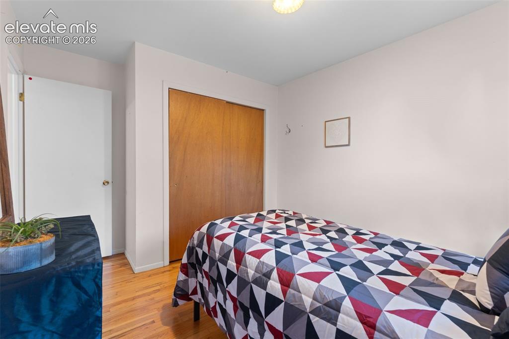 Image 20 of 50: Hardwood-style flooring, white interior door, and a built-in closet with wo