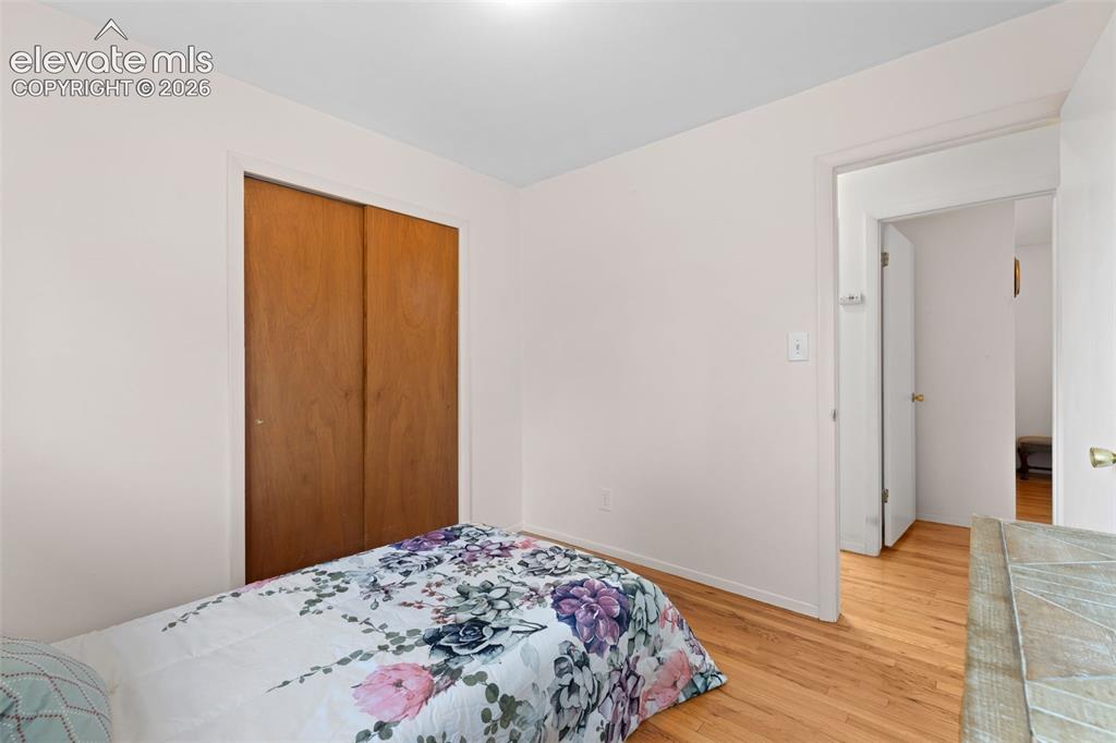Image 23 of 50: Hardwood flooring, sliding wood-finish closet doors, white walls, and white