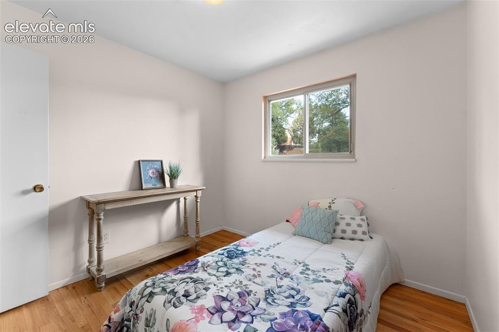 Image 24 of 50: Hardwood-style flooring with light wall tones, a white door, and a built-in