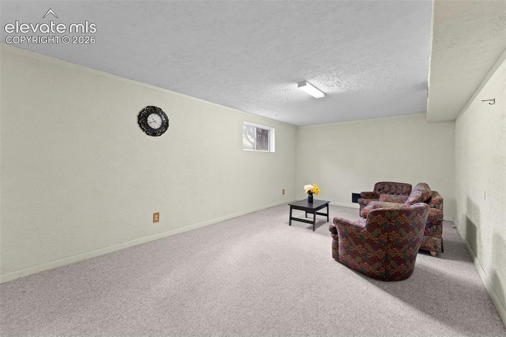 Image 34 of 50: Neutral-toned walls with textured finish, light-colored carpeting, a single