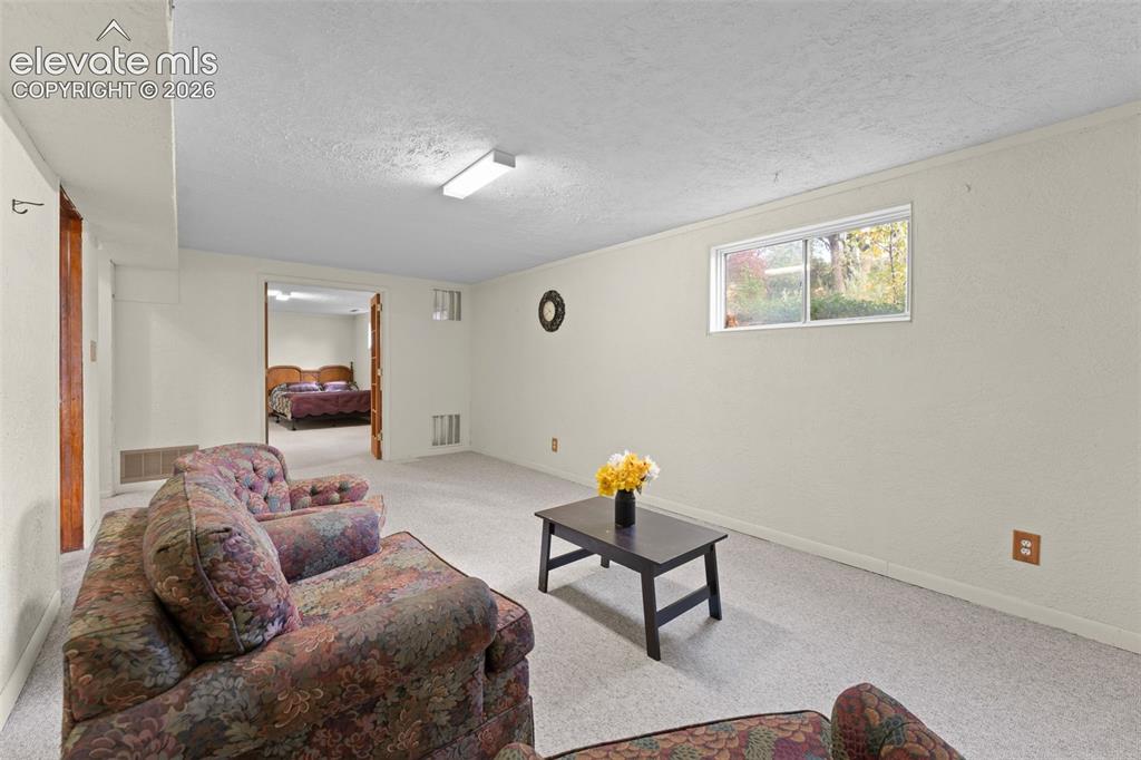 Image 37 of 50: Carpeted room featuring a double-hung window, recessed lighting, and a door