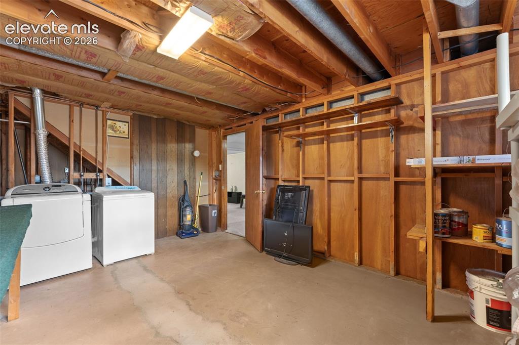 Image 41 of 50: Concrete flooring and exposed wood ceiling joists