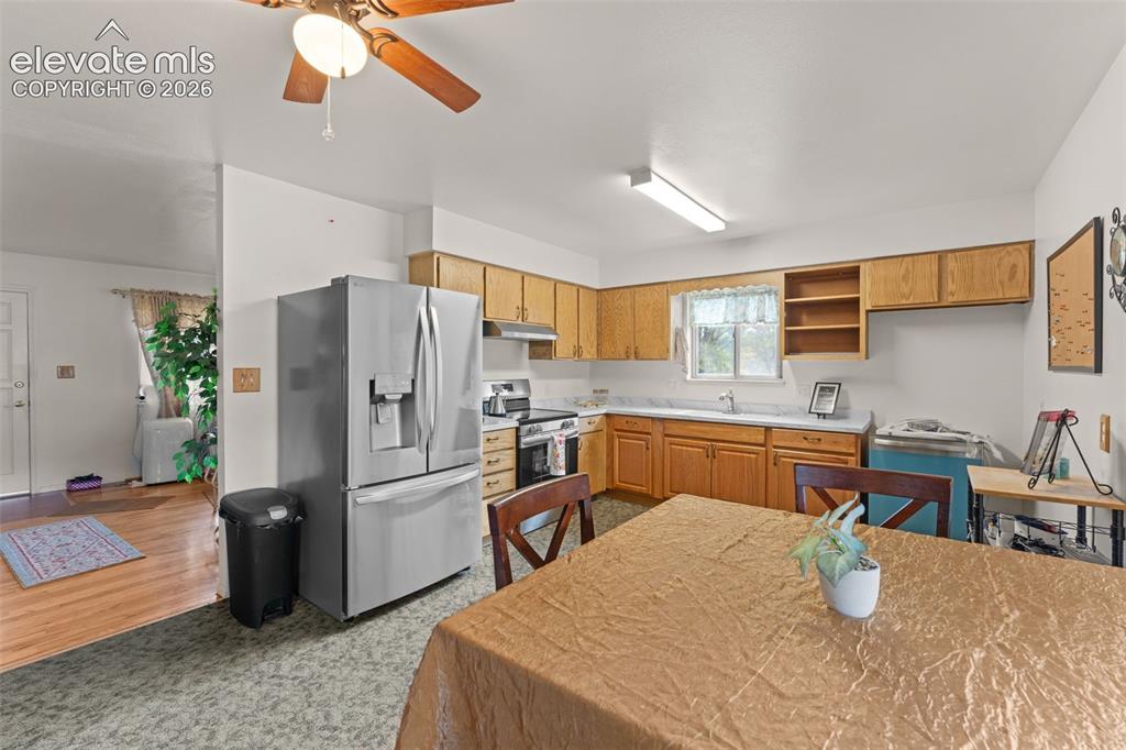Image 6 of 50: Kitchen featuring wood cabinetry, stainless steel refrigerator, white count