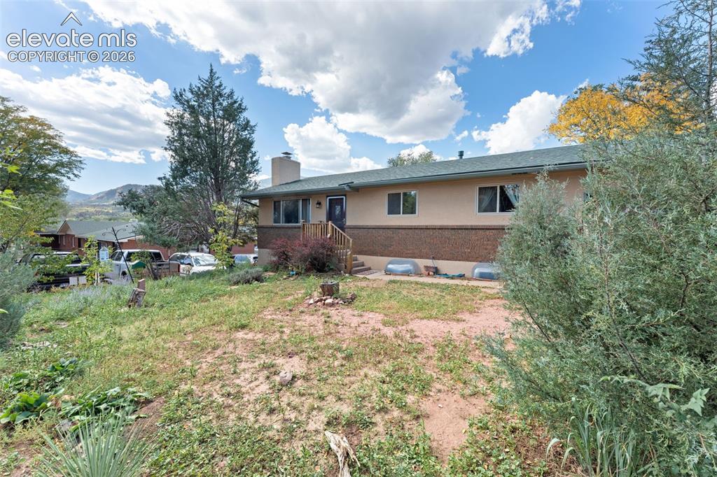 Image 7 of 50: Two-story residence featuring a brick foundation and a stucco exterior