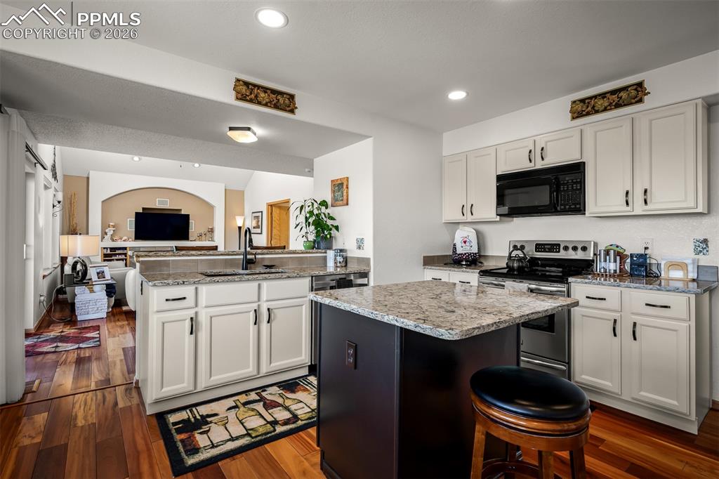 Image 11 of 50: Kitchen featuring light colored cabinetry, quartz countertops, and Brazilia