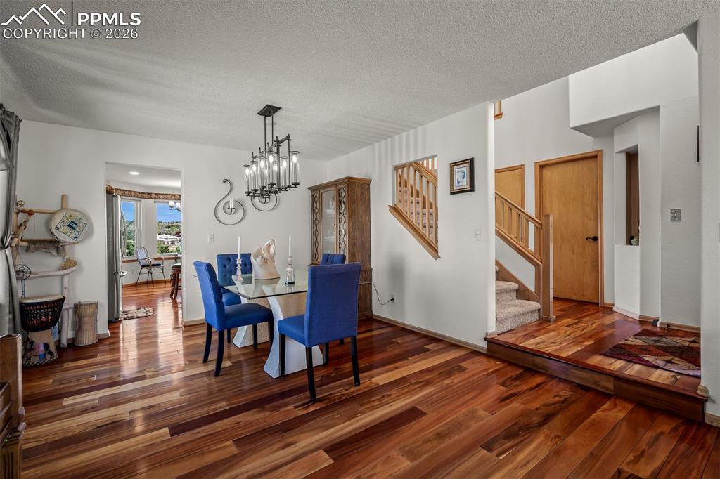 Image 16 of 50: Dining area featuring Brazilian Koa Hardwood flooring, a contemporary chand