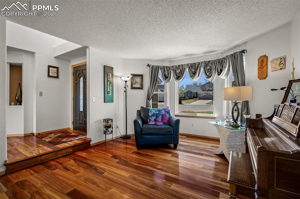 Image 18 of 50: Warm Brazilian Koa Hardwood flooring throughout, featuring a front bay wind