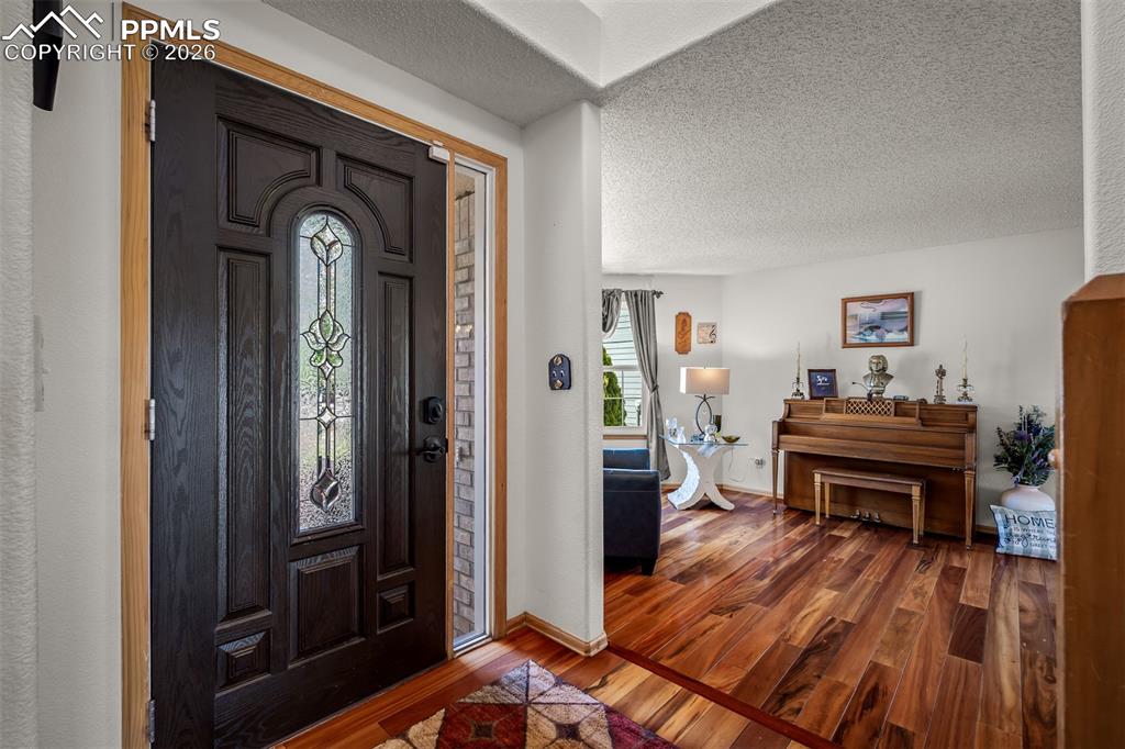 Image 20 of 50: Entryway featuring a dark paneled door with decorative leaded glass.

