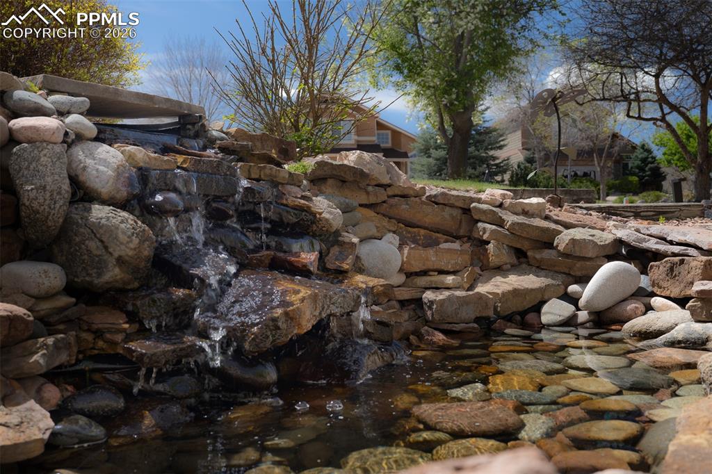Image 4 of 50: Amazing tiered stone waterfall feature with a rock-lined pond in the front 