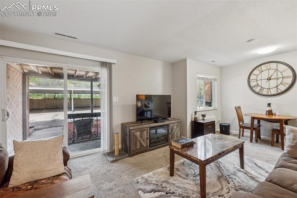 Image 3 of 11: Bright living space with natural light, neutral tones, and patio access.