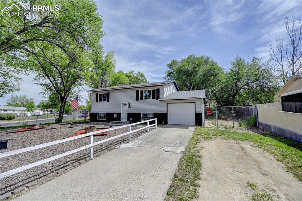 Image 2 of 30: Raised ranch with concrete driveway and a garage