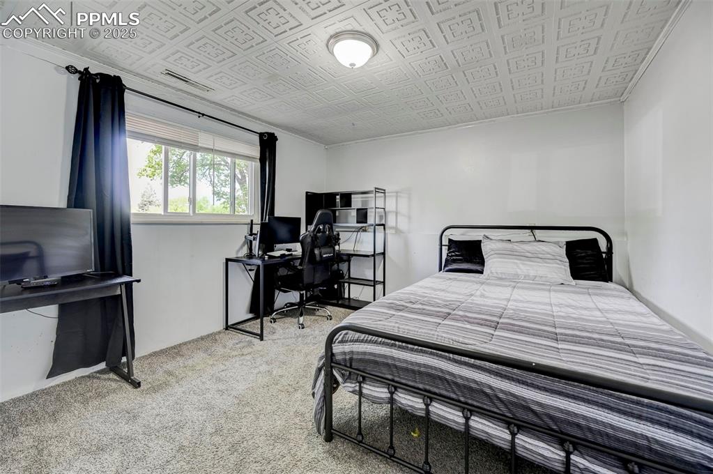 Image 20 of 30: Carpeted bedroom with ornamental molding, an office area, and an ornate cei