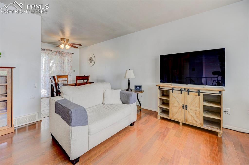 Image 6 of 30: Living area featuring ceiling fan and light wood-style floors