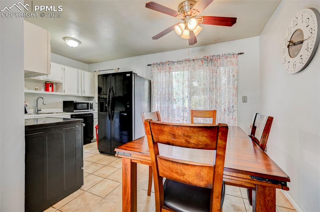 Image 9 of 30: Dining room featuring light tile patterned floors and ceiling fan