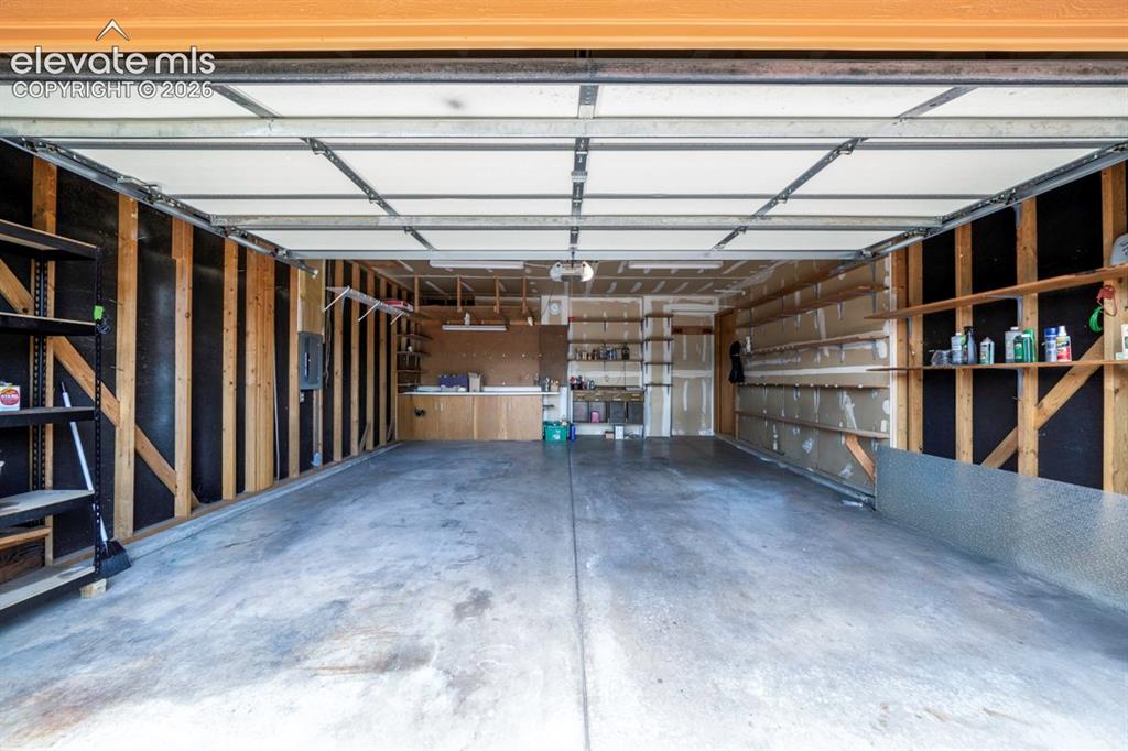 Image 41 of 45: oversized garage with workbenches & shelving