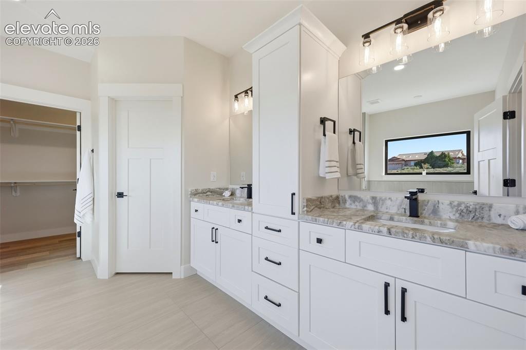 Image 25 of 50: Double vanities, walk in closet with built ins and toilet room