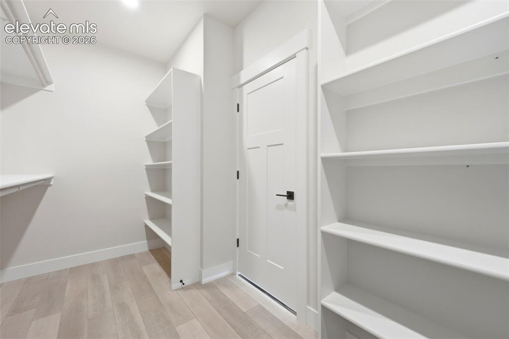 Image 27 of 50: Primary suite walk in closet with built ins